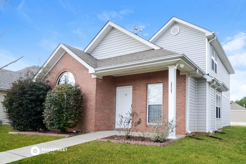 a brick house with white siding and a white front door