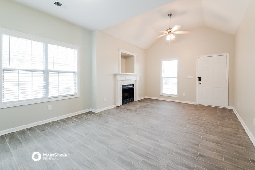 the living room of an empty house with a fireplace