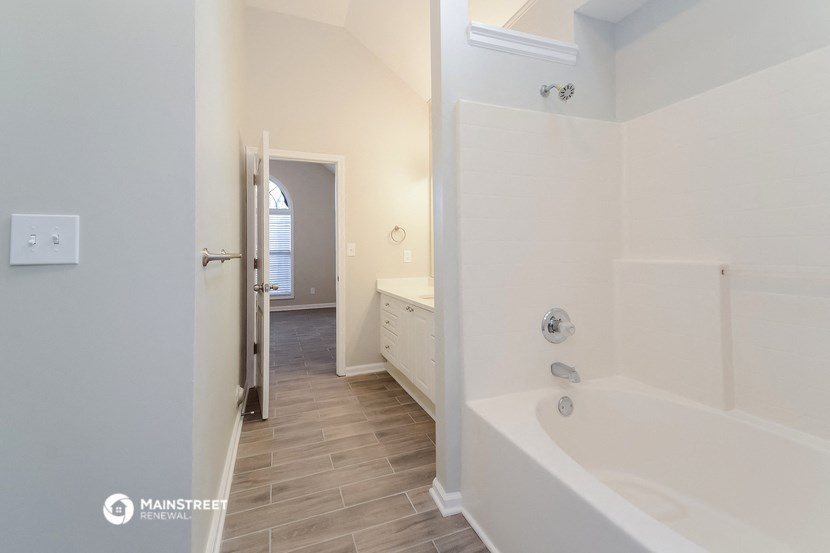 a large white bathroom with a tub and a sink