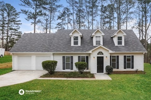 a white house with black shutters and a gray roof