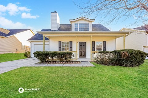 a white house with a front porch and a lawn