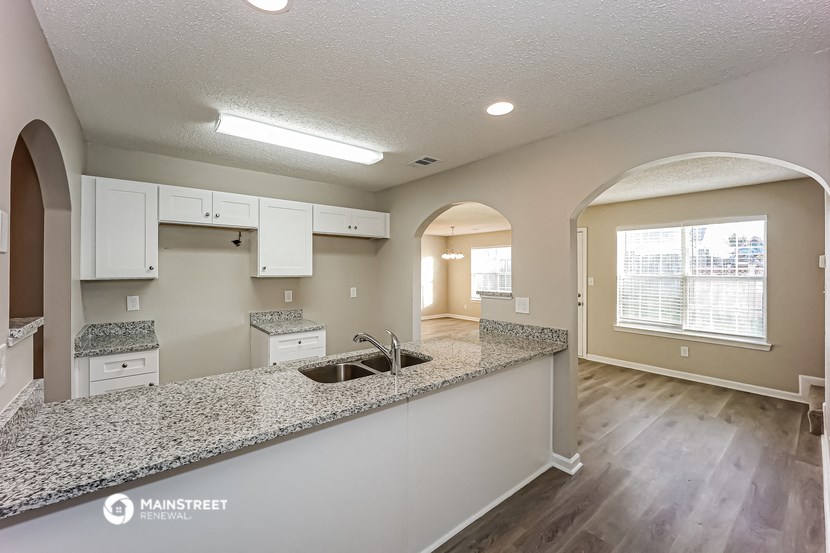 an open kitchen with granite countertops and a large window