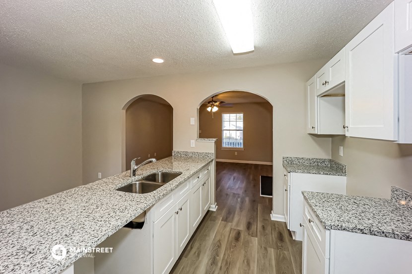 a kitchen with white cabinets and granite counter tops