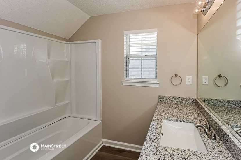 a bathroom with a tub and a sink and a mirror