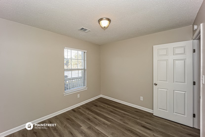 the interior of an empty room with a white door and a window
