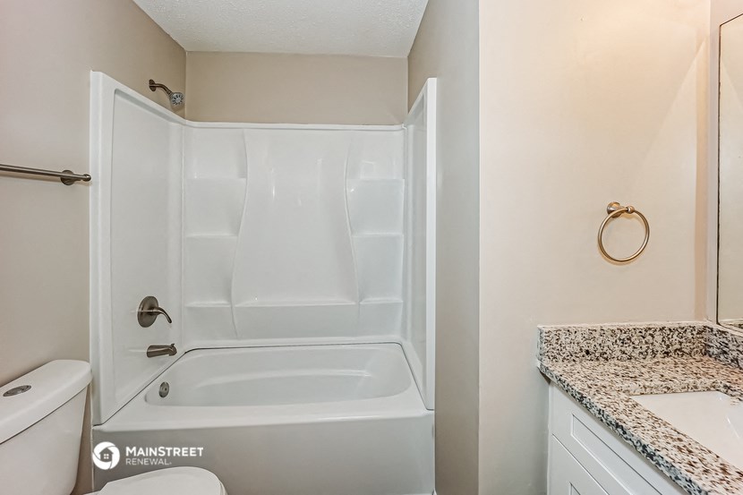 a bathroom with a tub and a sink and a toilet