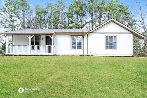 a small white house with a lawn in front of it