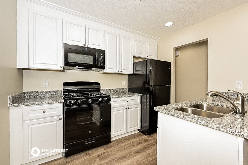 a kitchen with black appliances and white cabinets