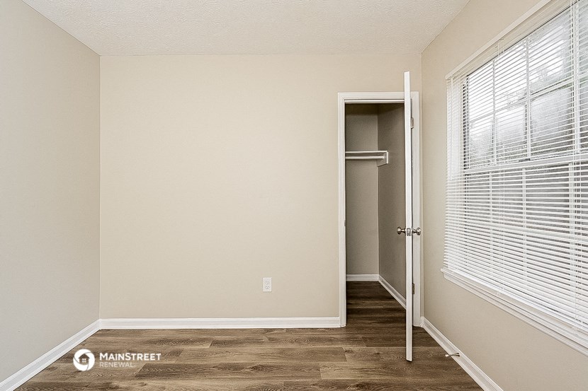 an empty room with a closet and a window
