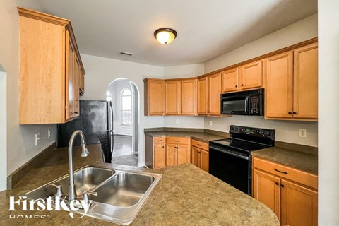 A kitchen with wooden cabinets and a stainless steel sink.