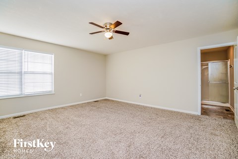 an empty bedroom with a ceiling fan and a closet