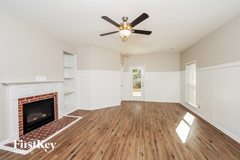 A room with a fireplace and a ceiling fan.