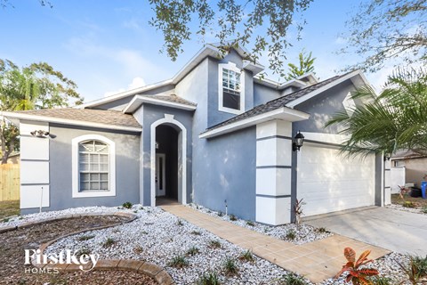 a blue house with a driveway and a garage door