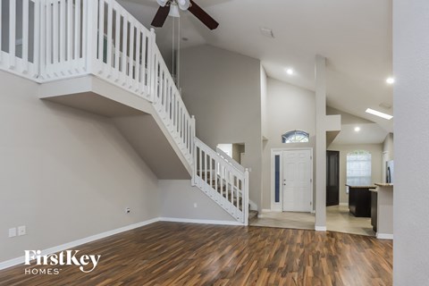 the foyer and living room of an open floor plan