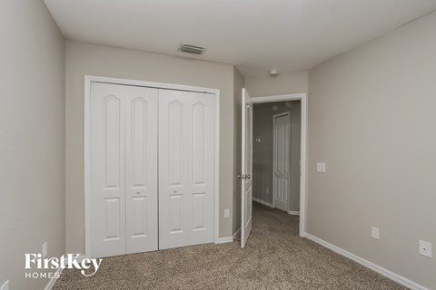 a bedroom with two closets and a door into a hallway