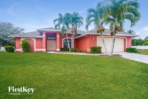 a pink house with palm trees in front of it