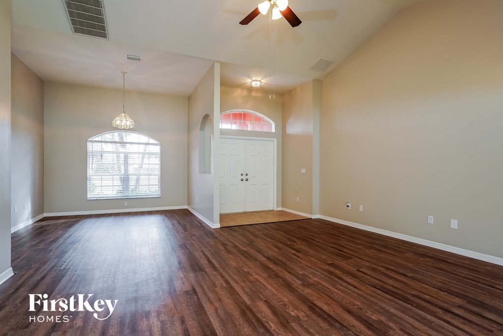 an empty living room with wood flooring and a white door