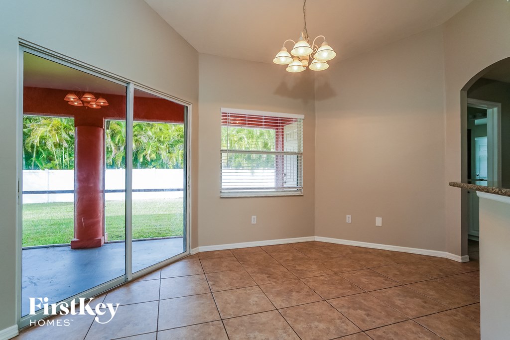 an empty dining room with a sliding glass door to the backyard