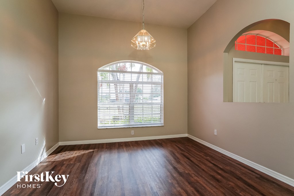 an empty living room with a large window and wooden floors