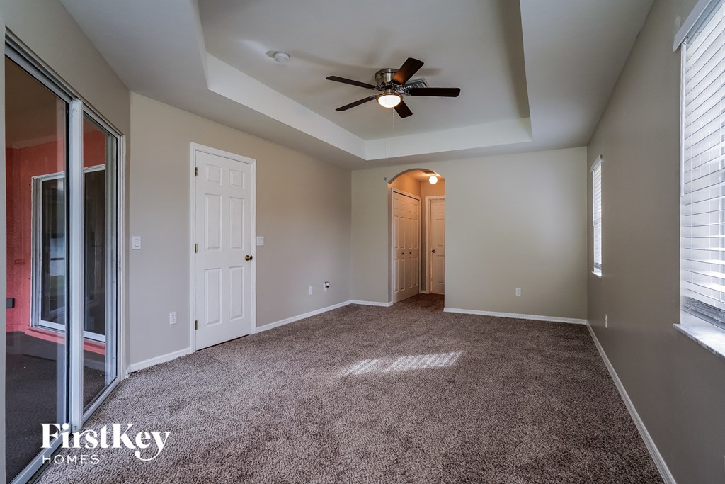 a living room with carpet and a ceiling fan