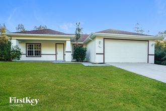 a home with a lawn and a white garage door