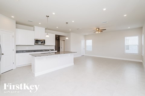A spacious kitchen with white cabinets and a countertop.