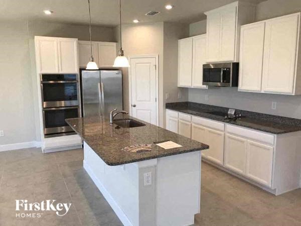 A kitchen with granite countertops and white cabinets.