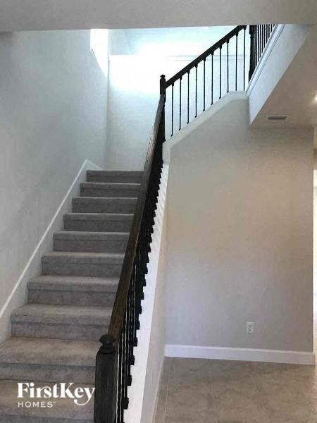 A staircase with a black railing and grey steps.