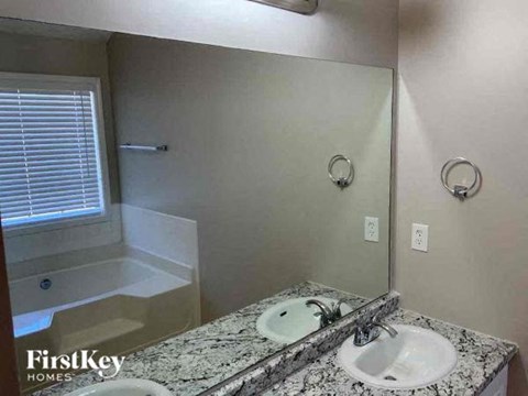 A bathroom with a marble countertop and a white sink.