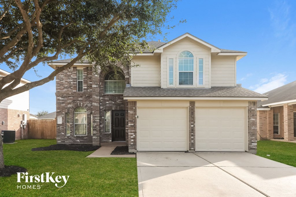 a house with a garage and a tree in the yard