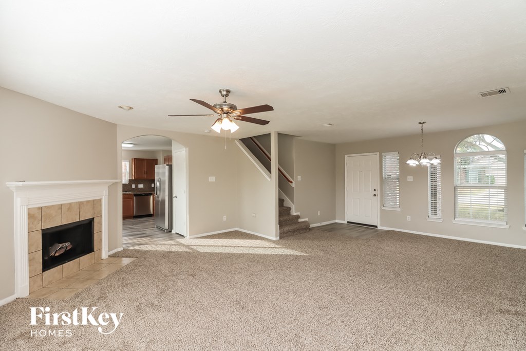 a living room with a fireplace and a ceiling fan