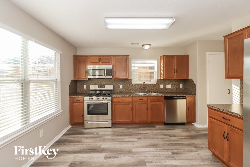 a kitchen with wooden cabinets and stainless steel appliances