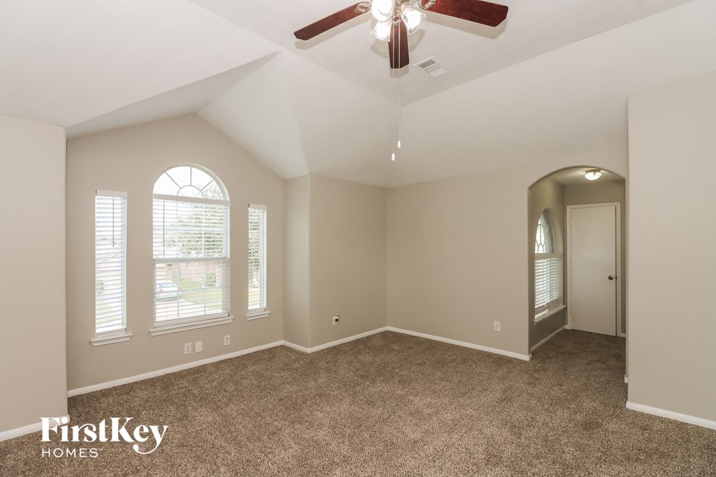 the master bedroom has a ceiling fan and a carpeted floor