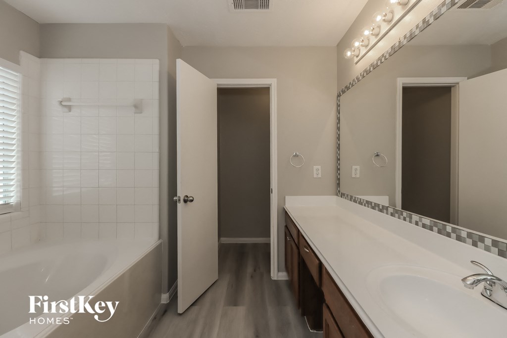 a bathroom with a sink and a shower and a mirror