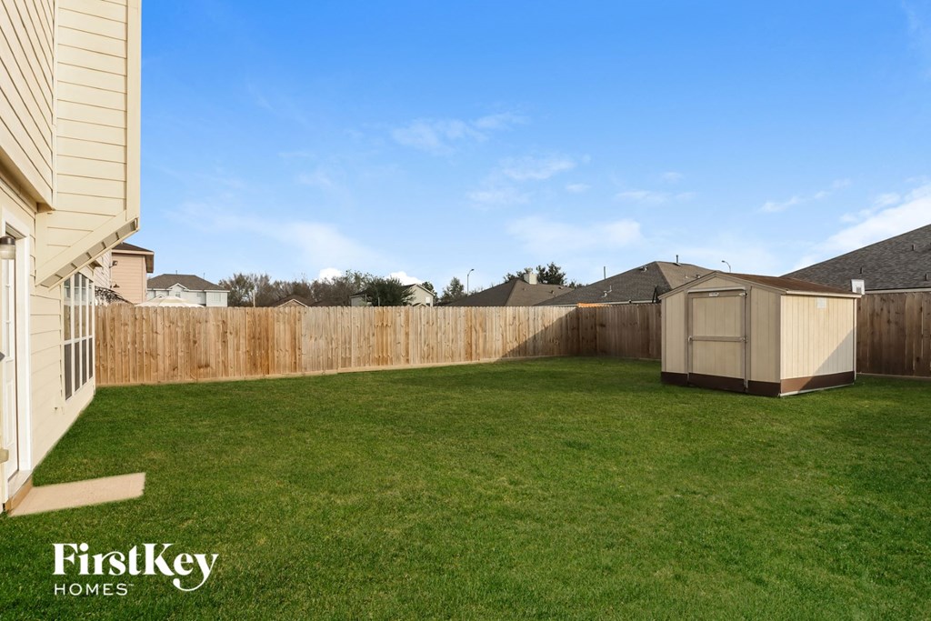 a backyard with a fence and a shed in it