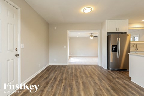 A kitchen area with a refrigerator and a sink.