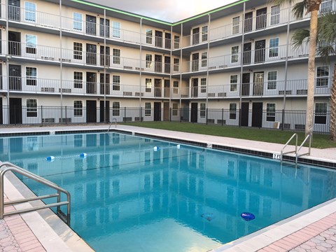 a large swimming pool in front of an apartment building