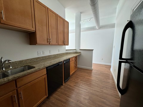 A kitchen with wooden cabinets and black appliances.