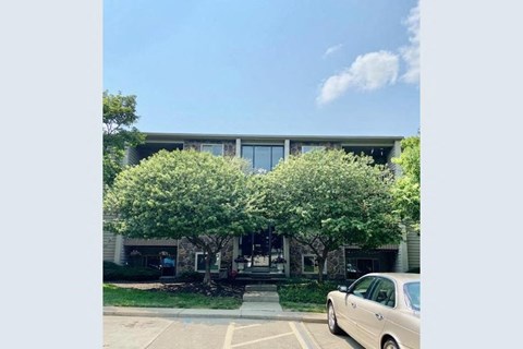 A car is parked in a parking lot in front of a building.