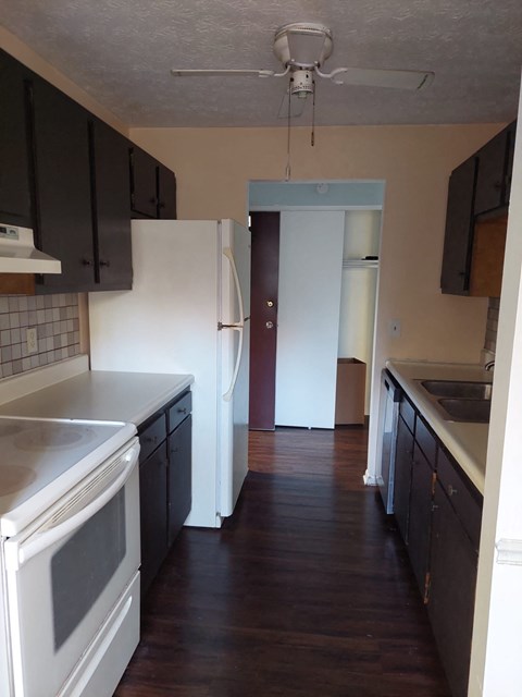 A kitchen with a white oven and black cabinets.