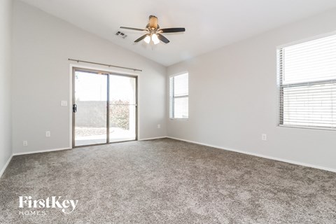 A spacious room with a ceiling fan and sliding glass doors.