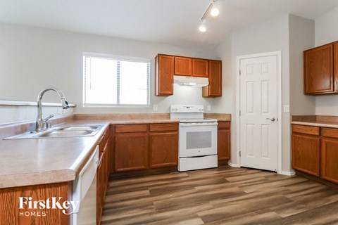 A kitchen with wooden cabinets and a white oven.