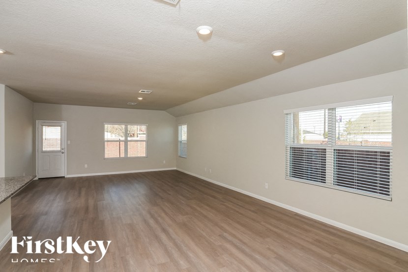 A spacious room with wooden flooring and a FirstKey Homes logo.