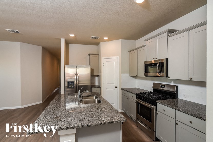 A kitchen with granite countertops and stainless steel appliances.