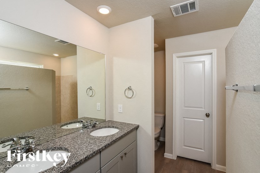 A bathroom with a granite countertop and a white door.