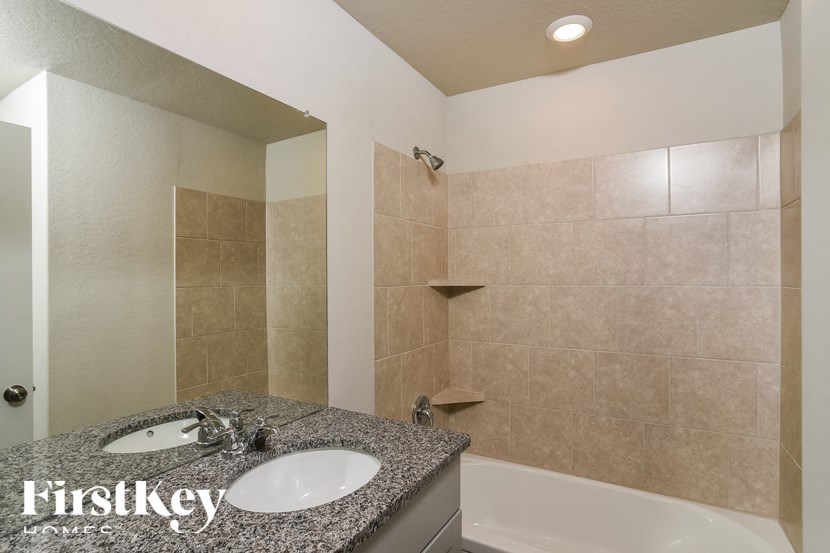 A bathroom with a granite countertop and a white sink.