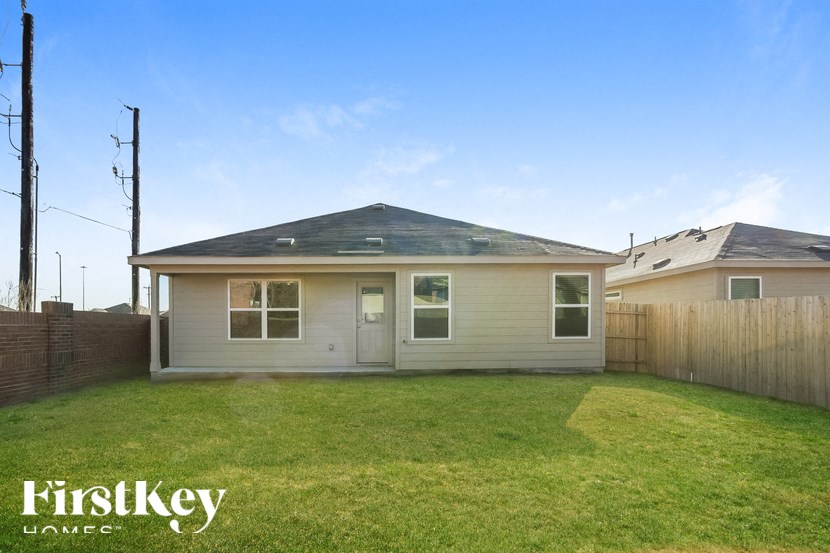 A house with a grey roof and a fence in front of it.