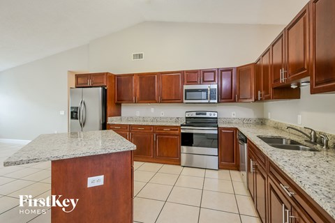 a kitchen with wooden cabinets and stainless steel appliances and granite counter tops
