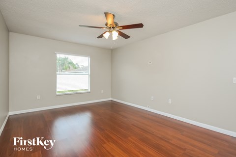 a living room with wood floors and a ceiling fan