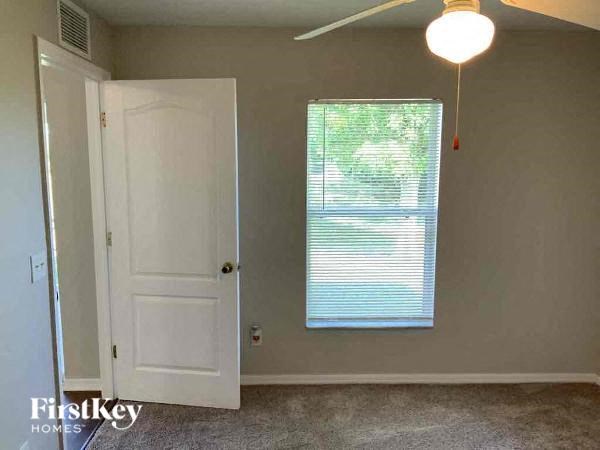 A room with a white door and a window with blinds.